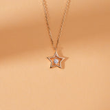 Gold star necklace with dangling diamond