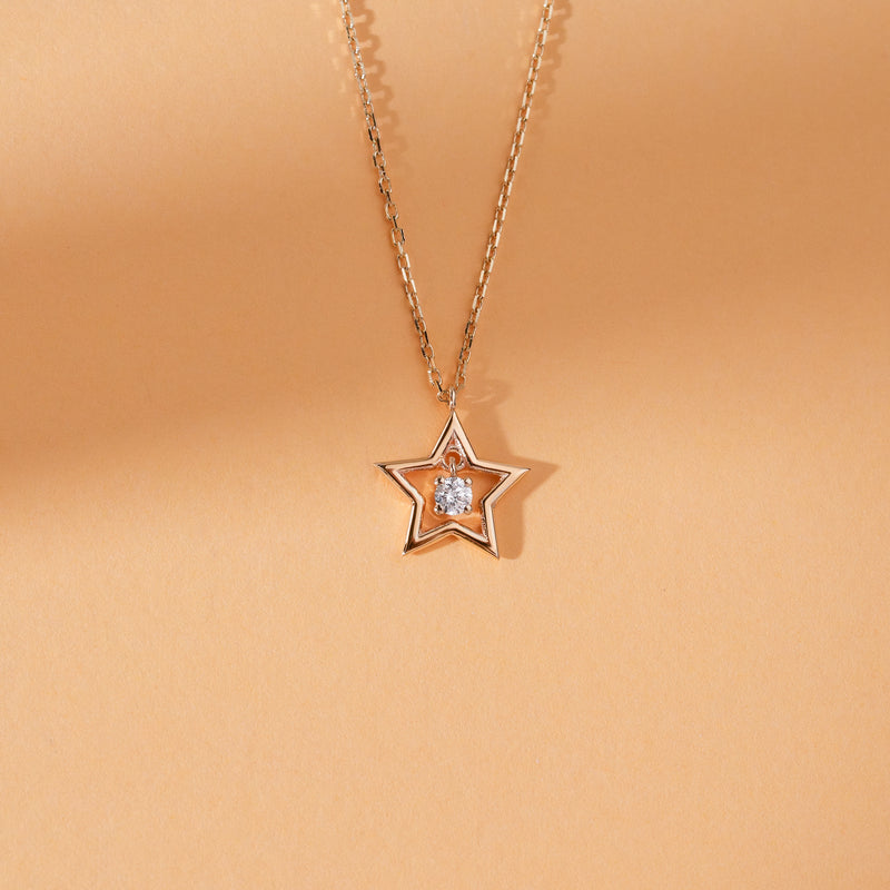 Gold star necklace with dangling diamond
