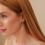 Model wears custom fine jewelry earring with april birthstone diamonds