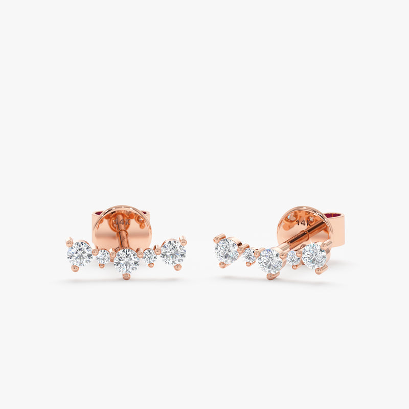 Pair of solid 14k rose gold curved bar stud earrings with multiple diamonds