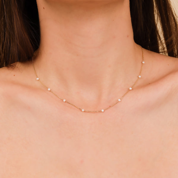 Close-up of natural pearls with a delicate gold chain showcasing their unique variations.