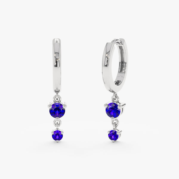 Solid white gold huggies with dangling natural blue sapphires.
