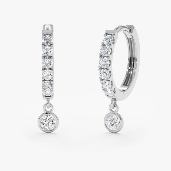 Handcrafted pair of solid 14k white gold diamond lined hoop earrings with hanging diamond bezel