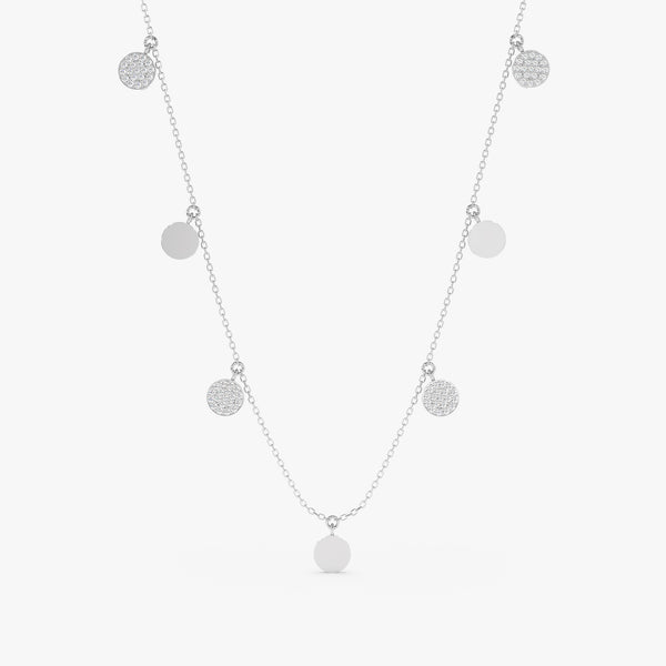 Mixed coin necklace featuring polished metal disks and sparkling diamond pave disks on a delicate chain.