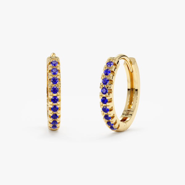 Handmade pair of solid 14k gold hoop huggies with blue sapphires