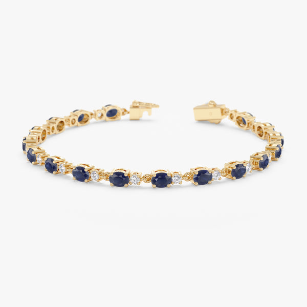Blue sapphire and diamond garland bracelet crafted in 18k yellow gold.