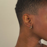 Video close up of model wearing thick solid gold huggie earrings