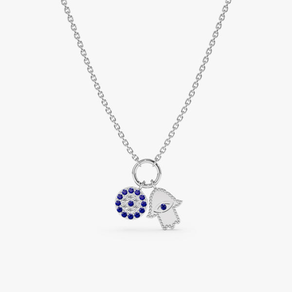 white Solid gold necklace with a sparkling blue sapphire Evil Eye charm and a diamond-studded Hamsa charm.