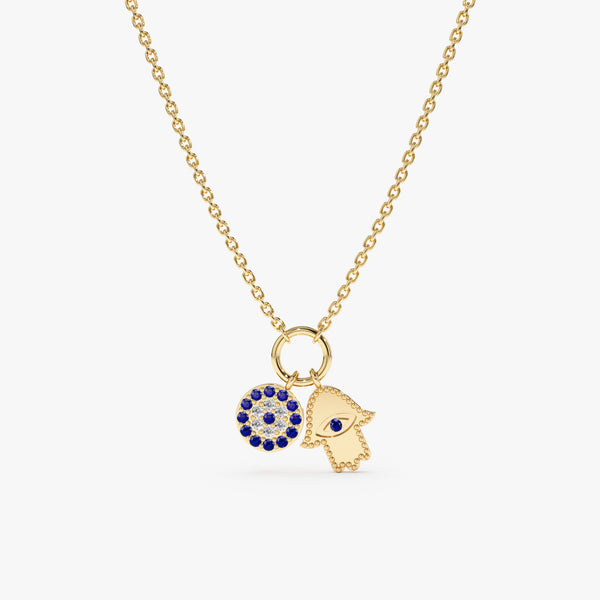 Evil Eye & Hamsa Charm Necklace in solid gold featuring a blue sapphire and diamonds on a dainty gold chain.
