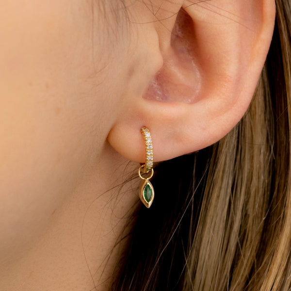 Model wears gold diamond emerald huggie earring charm in solid 14k gold