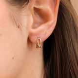 Close-up: Model wearing handcrafted dainty solid gold infinity hoops.