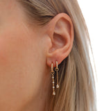 Model wears dangling diamond earring charm for huggies