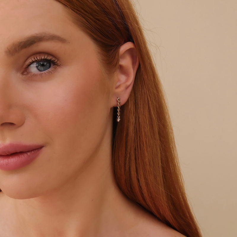 Model wears Dropdown cuban Chain Stud Earrings in 14k solid gold