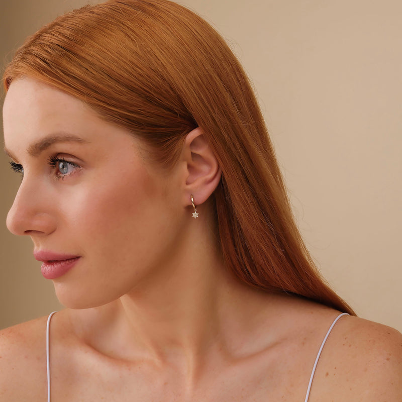 Model wears solid gold natural diamond star shaped charm earrings