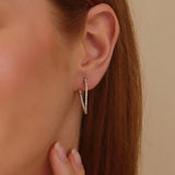 Model wears dainty Diamond Wavy Hoop Earring in 14k solid gold