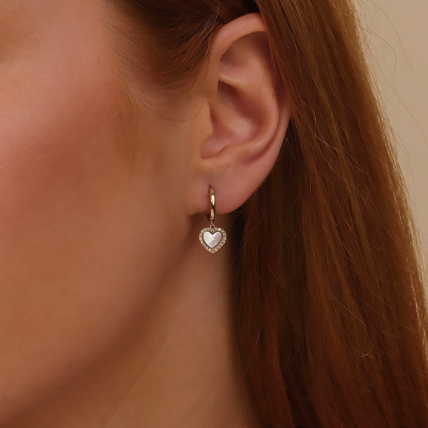 Dainty Mother of pearl heart-shaped huggie earrings.