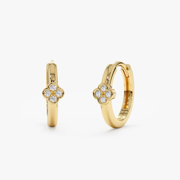 handmade pair of solid 14k gold huggie hoop earrings with four diamond clover bezel