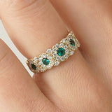 Vintage emerald diamond floral ring featuring natural emeralds and diamonds in a scalloped halo design.