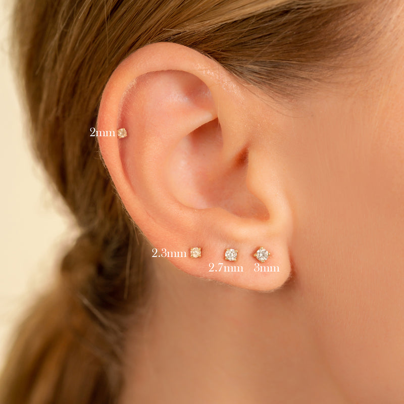 Model wears multiple sizes of a classic natural diamond stud for any occasion 14k solid gold