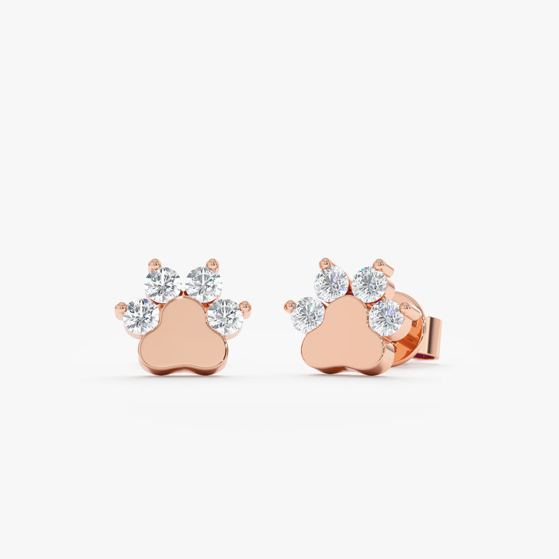 Product image of fine 14k solid rose gold earring studs in dog paw shape with natural diamonds.
