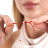 Small Gold Star Bracelet with Single Diamond worn by a model with red string and star charm.