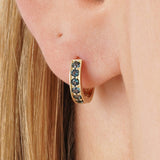 Tovi Infuse your style with the vibrant, sophisticated depth of our Teal Sapphire Huggie Hoops. This exquisite pair is crafted in lustrous solid gold, featuring a comfortable small hoop entirely lined with a continuous row of teal blue sapphires. The gems