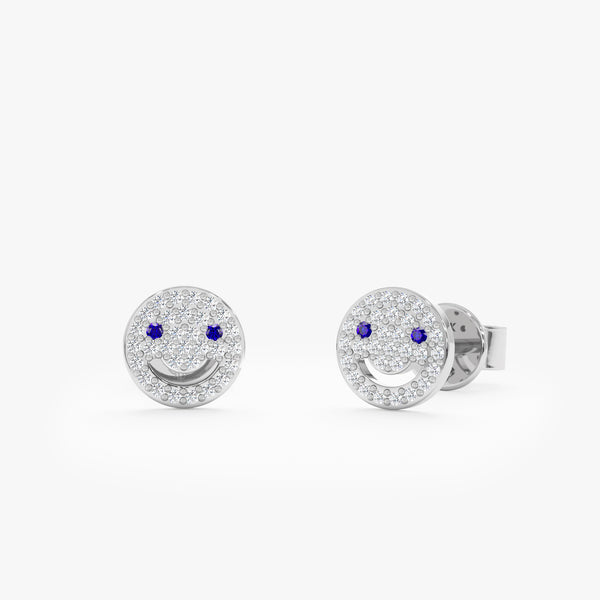 handcrafted pair of solid white gold smiley face stud earrings with diamonds and blue sapphire