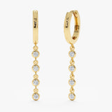 Pair of solid 14k gold drop down earrings featuring multiple white diamonds
