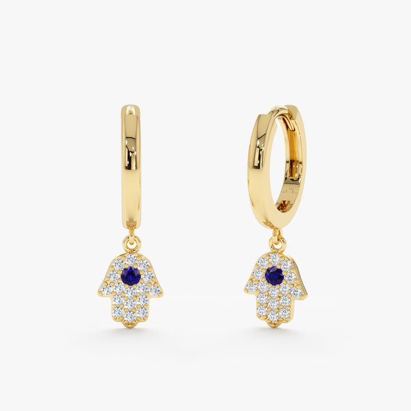 Pair of hamsa hand shaped charm huggie hoops in 14k solid gold with blue sapphire and diamonds