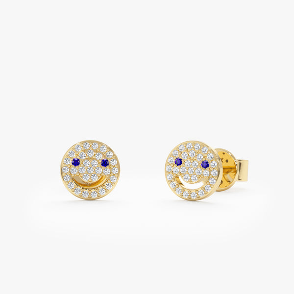 handmade pair of solid 14k gold smiley face earring studs with paved diamonds and blue sapphires