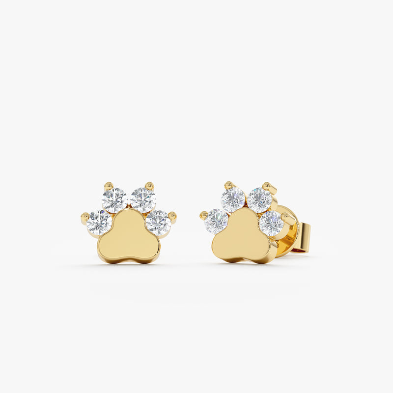 Product image of solid gold earring studs in dog paw shape with natural diamonds. 