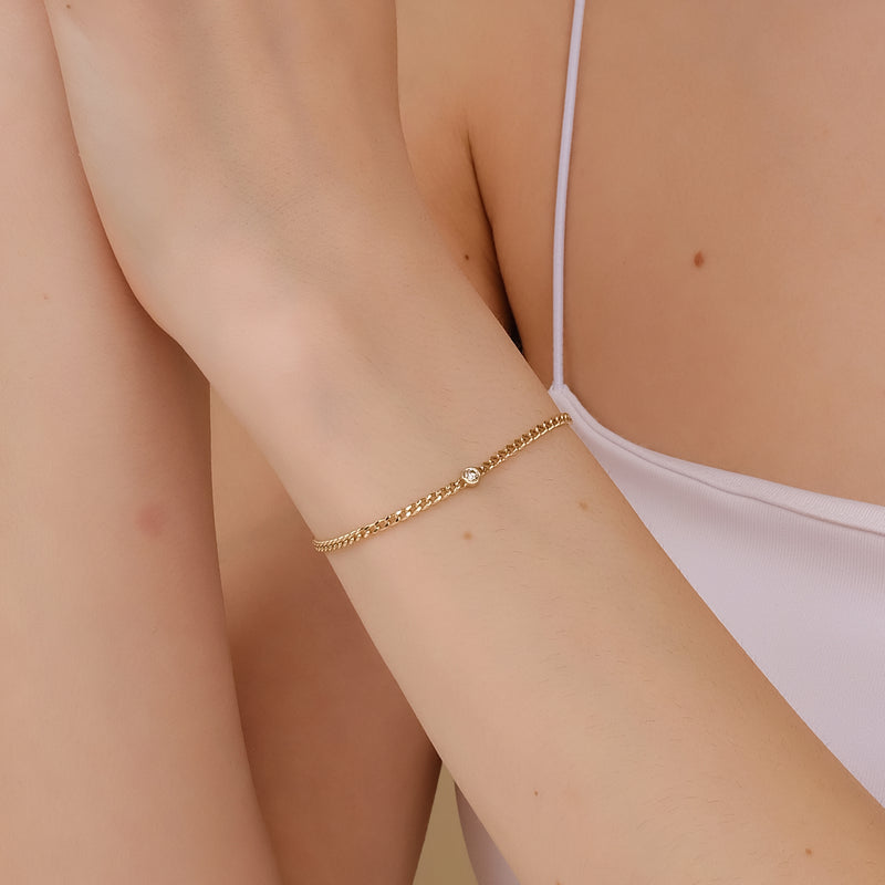 14k gold Cuban chain bracelet with a diamond set in a bezel.