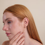 Model wearing handmade curved infinity symbol earrings with diamonds.