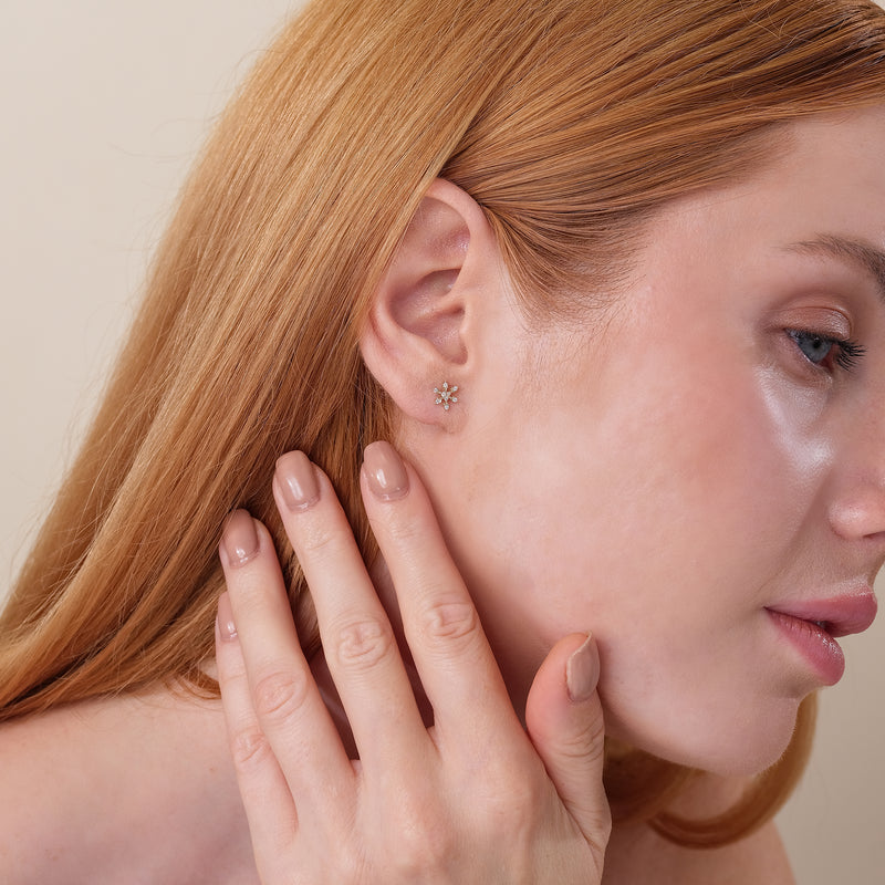 Model wearing radial diamond snowflake stud earrings in 14k solid gold gift for her.