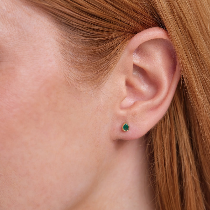 Model close up of elegant May birthstone pear cut emerald in solid 14k gold gift for her. 