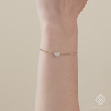 Yellow gold Cuban chain bracelet featuring a pearl heart charm