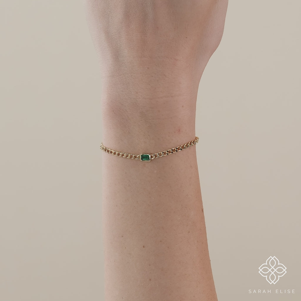 Handmade gold Cuban chain bracelet showcasing a vibrant emerald