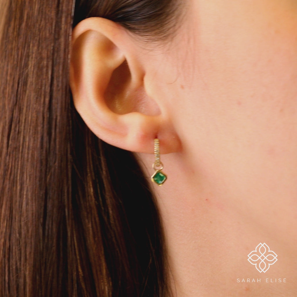 Video close up of handmade solid gold hoop with emerald earring charm