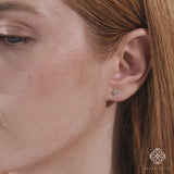 Close up video of model wearing dainty Natural diamond earring studs with 4-prong setting in solid gold.