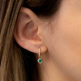 Model wears may birthstone emerald huggie charm in 14k solid gold