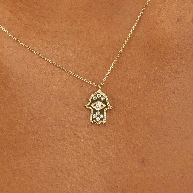 Elegant and protective Gold & Diamond Hamsa Necklace featuring a sparkling hamsa charm on a gold chain.