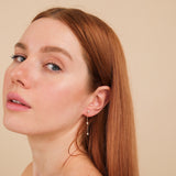 Model wears 3 station diamond bezel hanging earring stud 