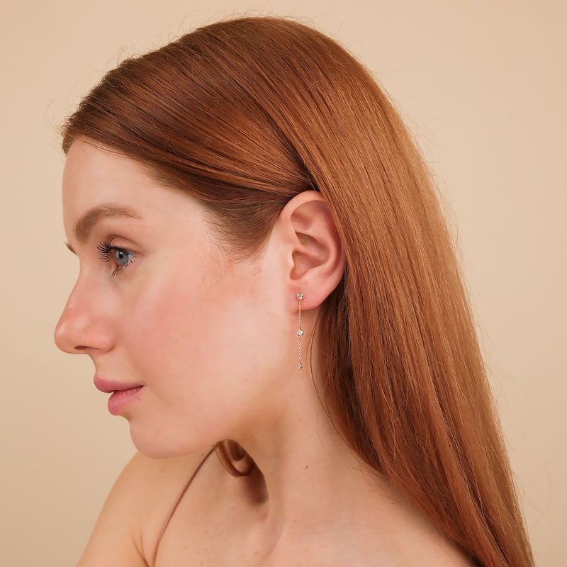 Model wears 3 bezel hanging diamond earring stud in 14k solid gold