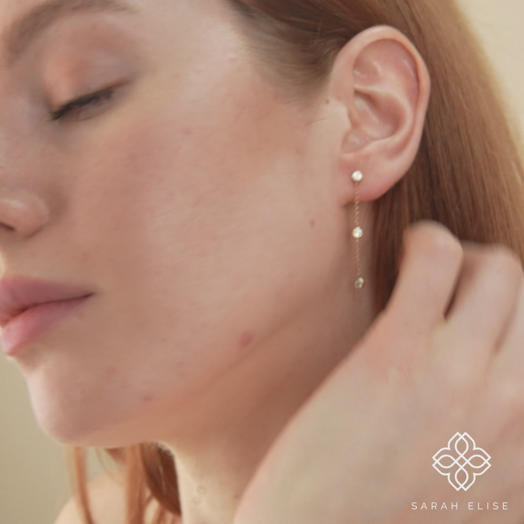 Video close up of petite minimalistic dangle earrings